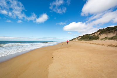 Scenic view of beach against cloudy sky