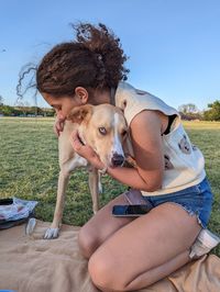 Low section of woman with dog on beach