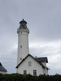 Low angle view of lighthouse against buildings