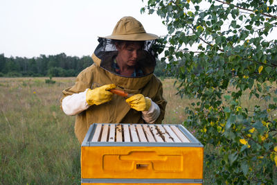 Portrait of young woman standing against plants