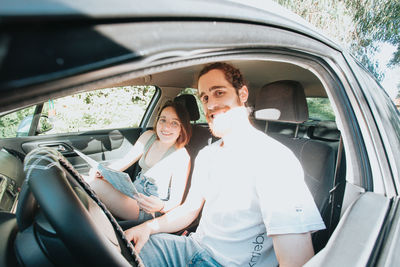 Portrait of smiling friends sitting in car