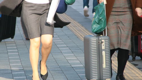 Low section of people walking on street