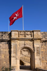 Low angle view of flag flags against clear blue sky