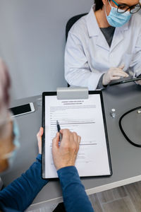 Midsection of man having discussion with doctor at clinic