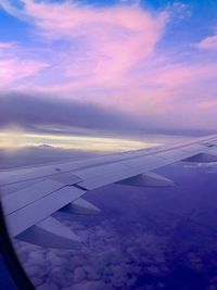 Airplane flying in sky at sunset