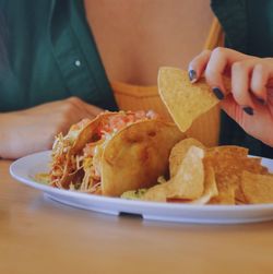 Woman holding taco chip 