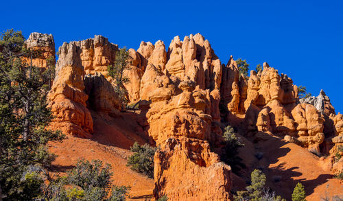 Panoramic view of rock formations against blue sky