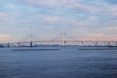 View of suspension bridge against cloudy sky