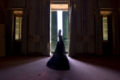 Full length woman standing at entrance of building