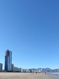 View of beach against clear blue sky