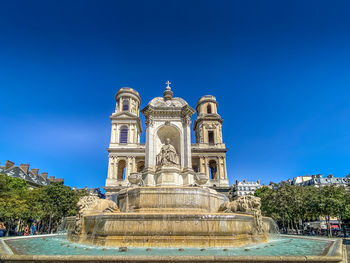 Low angle view of fountain against blue sky