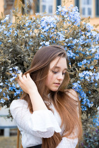 Young woman standing against plants outdoors