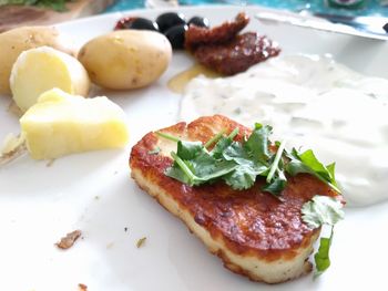 Close-up of meat served with sauce and potatoes