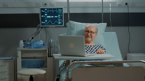 Smiling patient talking on video call at hospital