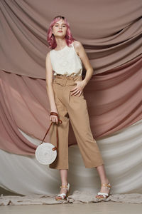 Portrait of woman standing against the wall