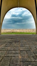 Footpath by street against sky