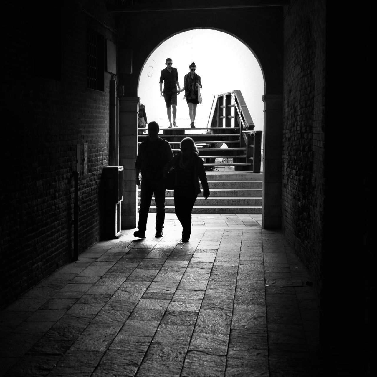 full length, indoors, rear view, men, walking, architecture, lifestyles, silhouette, built structure, arch, person, leisure activity, the way forward, standing, corridor, sunlight, day