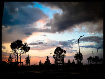 Silhouette street against sky during sunset