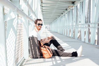 Smiling man sitting on bridge