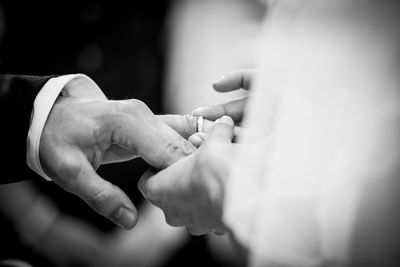 Woman wearing ring to groom during wedding