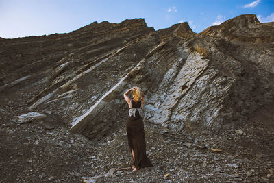 Rear view of man standing on rock