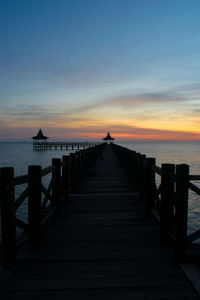 Pier over sea against sky during sunset