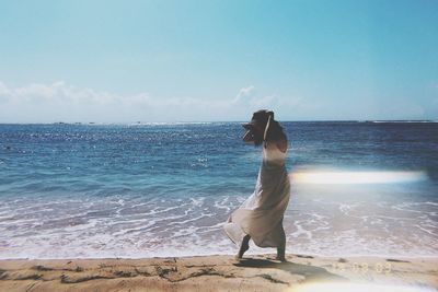 Woman looking at sea against sky