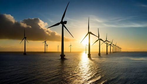 Marine wind farm produces energy with zero environmental impact. wind turbines in the sea at sunset