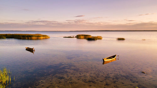 Scenery of sail boats on lake dryvyaty on sunny summer day, sunset light. boarding point shoal water