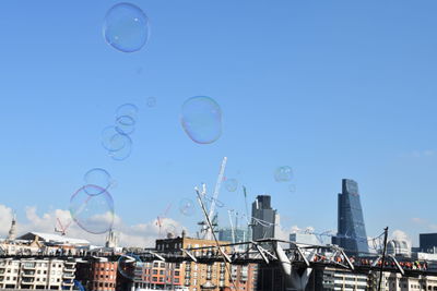 Bubbles against rainbow in city