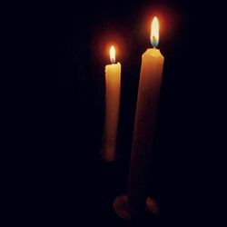 Close-up of lit candle in dark room