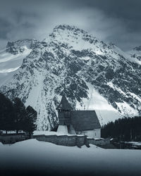 Scenic view of snow covered mountains and trees against sky