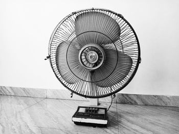 Close-up of electric lamp on table against wall