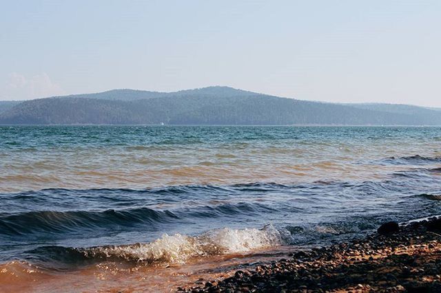 SCENIC VIEW OF SEA WITH MOUNTAIN IN BACKGROUND