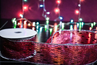 Close-up of red lace and illuminated lighting equipment on table