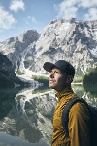 Backpacker looking at view by lake against mountains