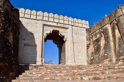 Low angle view of fort against clear blue sky