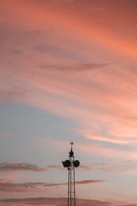 Low angle view of communications tower against sky during sunset