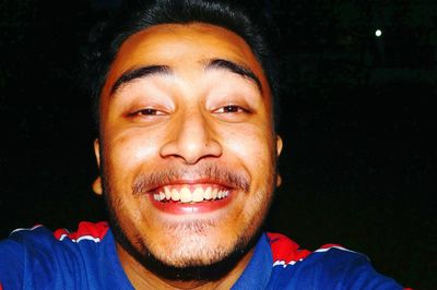 Portrait of smiling mid adult man against black background