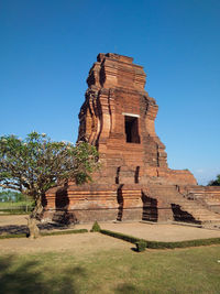 Built structure on landscape against clear blue sky