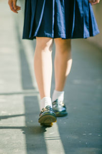 Low section of schoolgirl walking in corridor