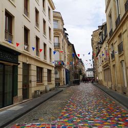 Street amidst buildings in city against sky