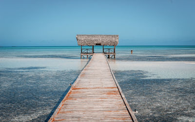 Scenic view of pier on sea against clear blue sky