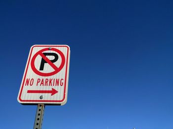 Low angle view of no parking sign against clear sky