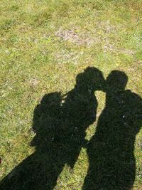 Shadow of couple on heart shape on field