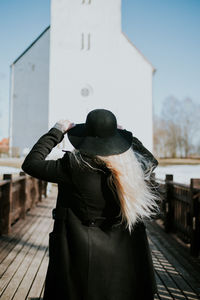 Rear view of person wearing hat standing in city