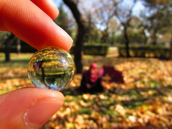 Close-up of hand holding tiny crystal ball