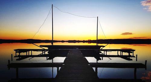 Pier on table by sea against sky during sunset