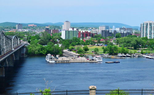 Boats in river with city in background