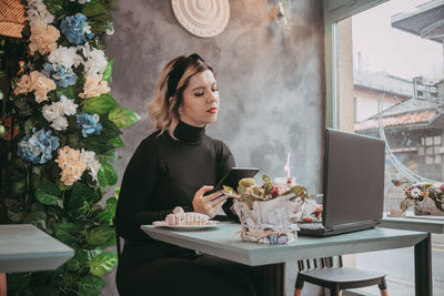 Young woman sitting on table in restaurant